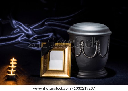 black cemetery urn with golden mourning frame for sympathy card