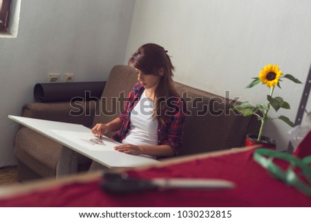 Young fashion designer making a sketch of a new dress design