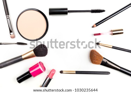 Makeup brushes, pencil, lipstick, and other objects, forming a frame on a white background, with copy space. A template for a makeup artist's business card or flyer design