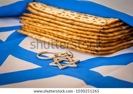 Matzah, traditional Jewish unleavened bread, wrapped up in a flag of Israel. David Star ("Magen David"), Pesach concept, Jewish Passover stock image.