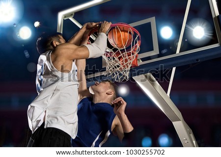 Two basketball players in action in gym