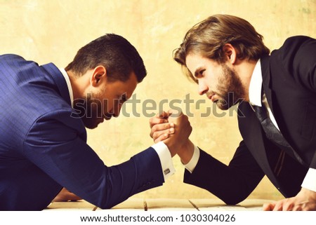 Business, partners, crisis and confrontation concept, businessmen arm wrestling in office
