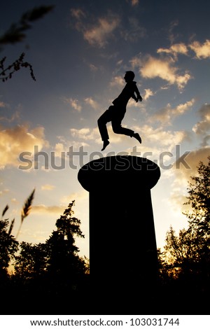 silhouette of gymnast jumping in sunset on tower