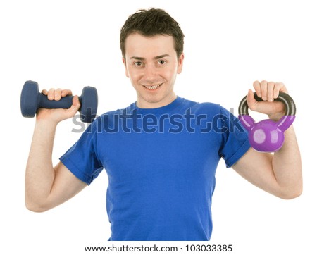 A man holding up a kettleweight and a dumbell, isolated on white