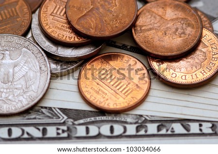 Close up of many American cent (Penny) and other small American coins on a One Dollar note. Concept photo of money, banking ,currency and foreign exchange rates.  No people. Copy space