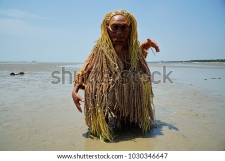 An unidentified man wearing a wooden mask for the Mahyin Jo-oh dance during the annual Puja Pantai (Ocean Healing) rituals.