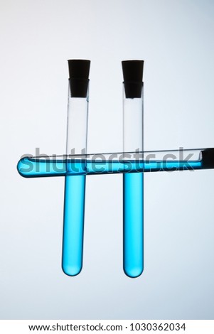 test tubes filled with blue liquid on grey