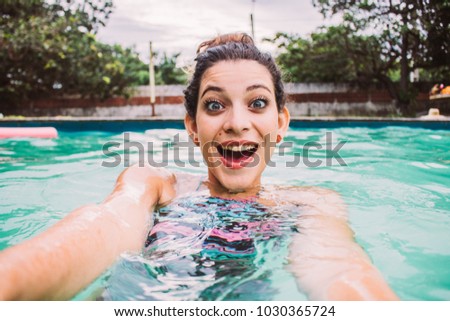 Young mixed woman in the pool, take a selfie portrait