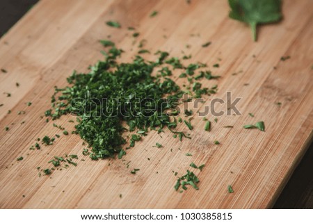 Cutting parsley on wooden desk