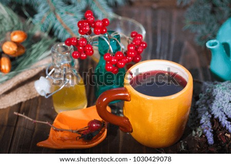 Herbal tea from the viburnum decoction of red sea buckthorn berries and thyme in a transparent glass mug in the village on a wooden table