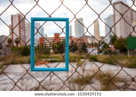 blue frame for photograph. fence from the mesh. mock up.