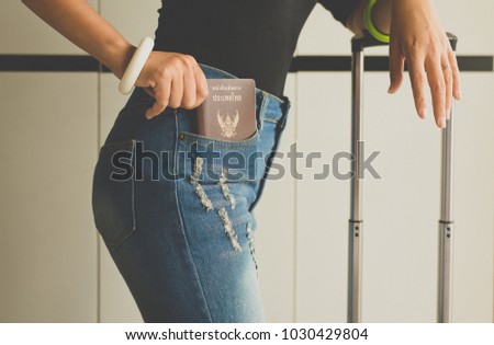 Hand holding passport in blue jeans pocket,Retro styled Close up