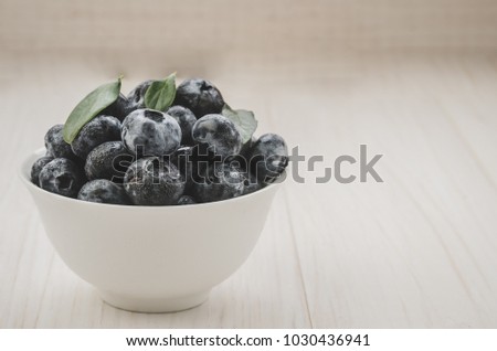 Fresh raw organic blueberry in white cup on white background/Fresh raw organic blueberry in white cup on white background. copy space. Toned