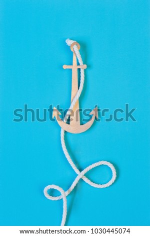 Blue background with handmade paper anchor and rope