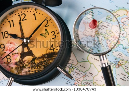 Planing for travel to France Paris with worldmap globe magnifying glass and alarm clock. Travel time in Europe concept. European holidays. traveling background with copy space.