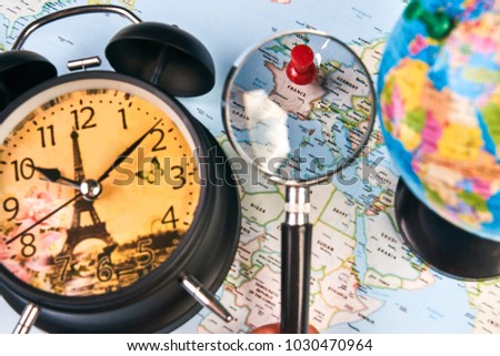 Planing for travel to France Paris with worldmap globe magnifying glass and alarm clock. Travel time in Europe concept. European holidays. traveling background with copy space.