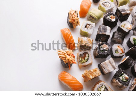 Salmon sushi and rolls - japanese food restaurant delivery, closeup of platter set on white background, copy space