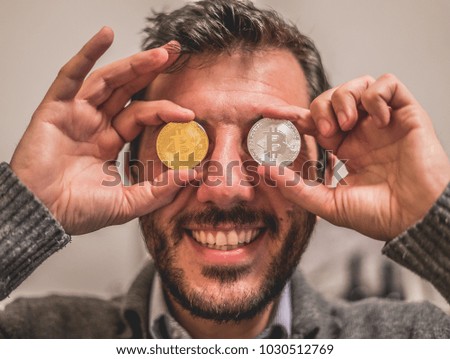 handsome man crazy face with coin bitcoin on eyes 