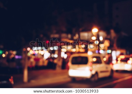 Blurred background night street with cars motion and cozy street with cafe, Spain.