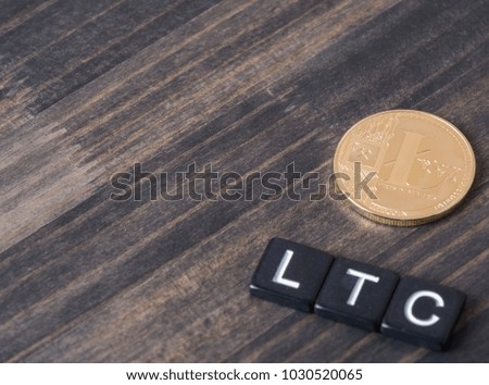 Litecoin cryptocurrency with letters LTC on wooden table top