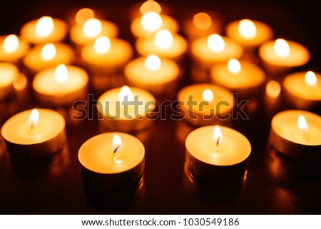 Kemerovo, Russia, fire in the mall, burning candles. Shallow depth of field. Many candles burning at night. Candles background. Many candle flames glowing on dark background. Close-up. 