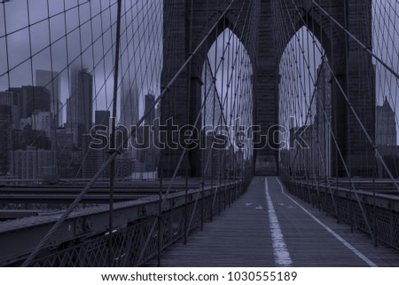 Moody morning in the city. Brooklyn Bridge, New York in black and white with blue tint 