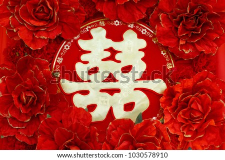 Chinese wedding symbol paper cut and red flowers decorated on the wall. Chinese Wedding with Double Happiness Text Calligraphy Illustration on paper cut design.