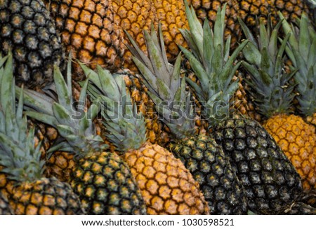 Pinneaples in closeup. Photo picked in popular market, fruits exposed to sale.
