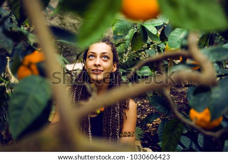 Young cute smiling woman in park with oranges