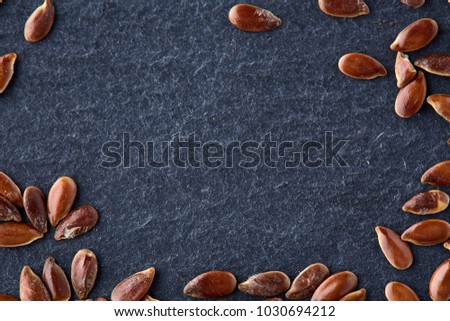 Top view close-up picture of separate flax seed on dark grey background, macro.