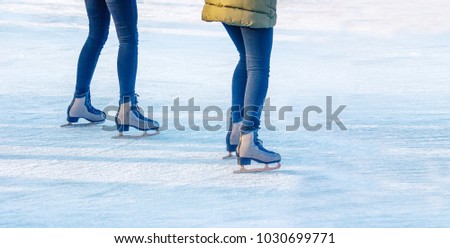two young girls are skating on the rink. feet closeup