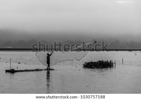 Fisherman spreading the web to fishing in JOMBOR water dam, black and white photo