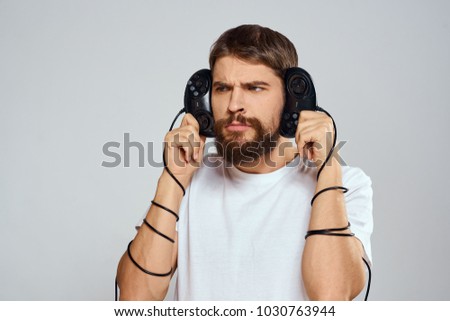 man holds the joystick at the head on a light background                              