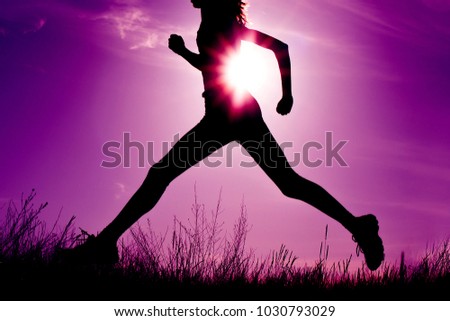 Running woman at dramatic sunset. Sport and freedom concept, toned image