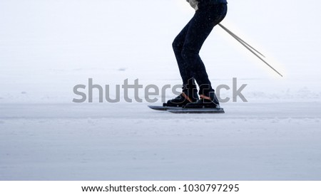 A person cross-country ice skating on a frozen lake.