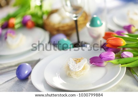 Beautiful table setting with crockery and flowers for Easter celebration. Glassware and cutlery for catered event dinner.