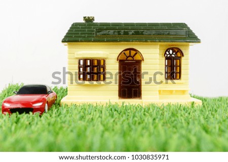 House and a car miniature with white background. Property concept.