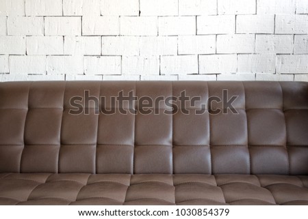 Interior mock up photo. White brick wall with leather sofa. Background photo with copy space for text.