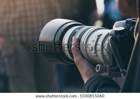 Closeup Telephoto lens with camera on hand 
