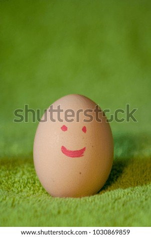 Easter concept. White chicken eggs drawn with a red smile located on a green background