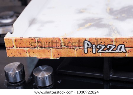 Used cardboard pizza box with grease stains lesft on its bottom