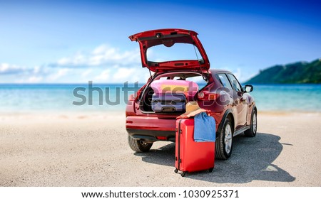 Summer time and red car on beach with few suitcase. Free space for your text or product.  Royalty-Free Stock Photo #1030925371