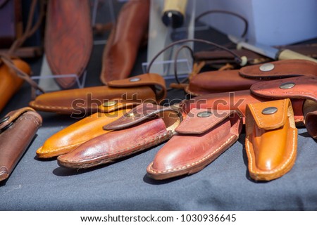 View of Closeup of hand tooled leather pocket knife cases or sheaths. Royalty-Free Stock Photo #1030936645