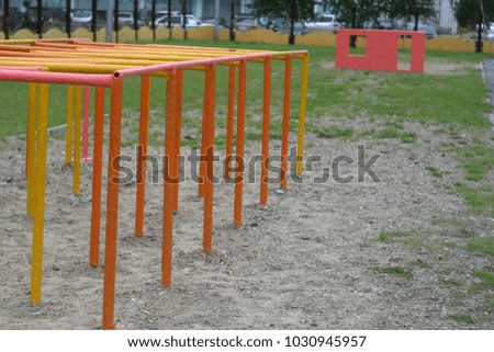 The iron labyrinth on the playground and the support of the horizontal bar. Summer background 