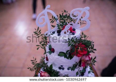 Wedding decoration letter D & B on the Beautiful white wedding Cake with Pink flowers and greenery. Wedding