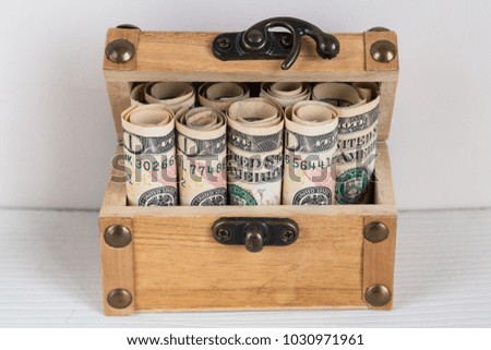 Dollars in the wooden box on the white background.