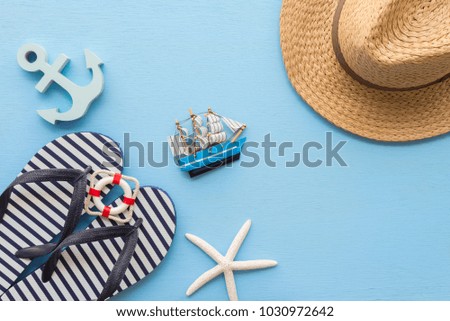 Flat lay of tropical beach summer holiday with beach summer accessories for traveling on blue wooden background