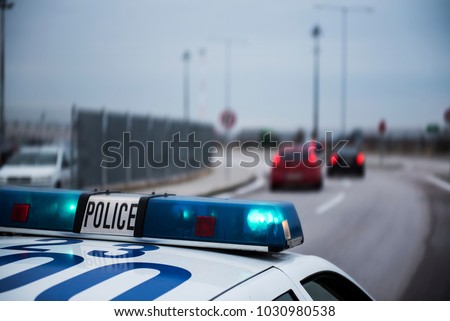 Police car following cars inside a city with motion blur effect. Royalty-Free Stock Photo #1030980538