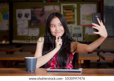 Portrait of thai teen beautiful girl in Chinese dress using smart phone Selfie