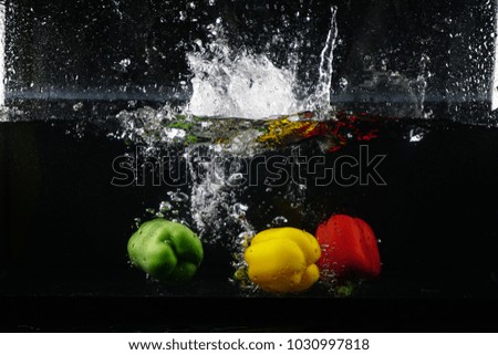 Drop Three Bell Pepper in to water with black background